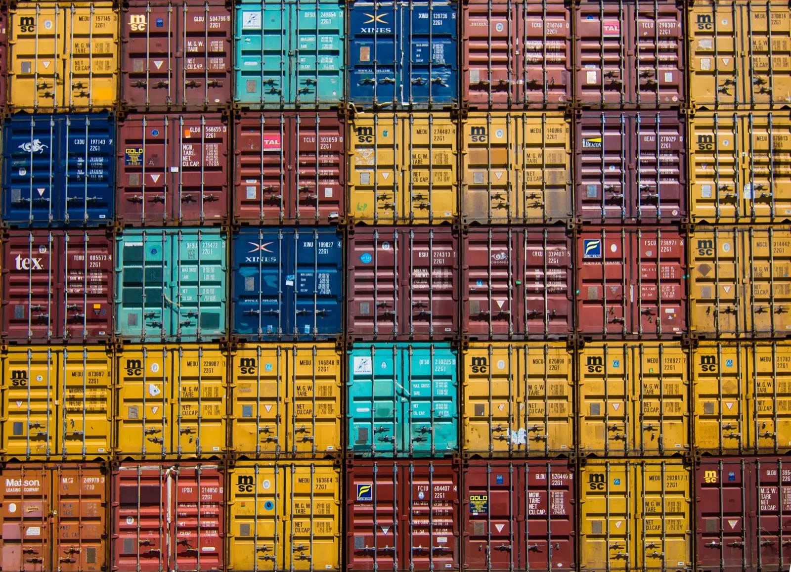 Colorful shipping containers stacked in a dense grid, a metaphor for a layered tech stack (photo: Guillaume Bolduc, Unsplash, CC0)
