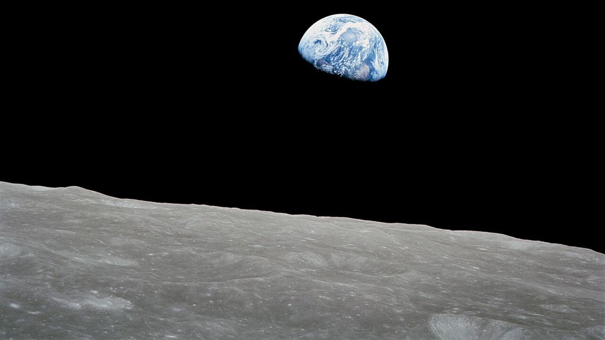 Earthrise as photographed by Apollo 8 in 1968: Earth hanging above the gray lunar horizon (photo by NASA, public domain)