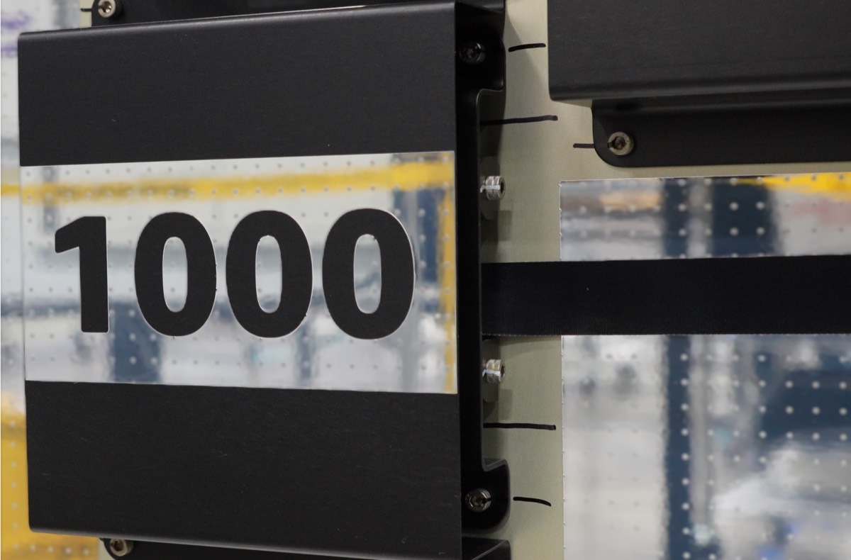 Close-up of a black satellite panel labeled 1000 on a production line