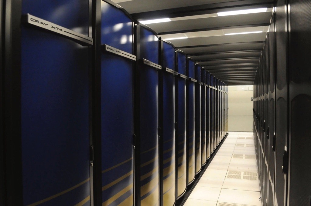 Two rows of dark blue supercomputer cabinets in a data center aisle