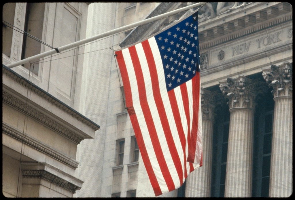 The New York Stock Exchange facade with a US flag