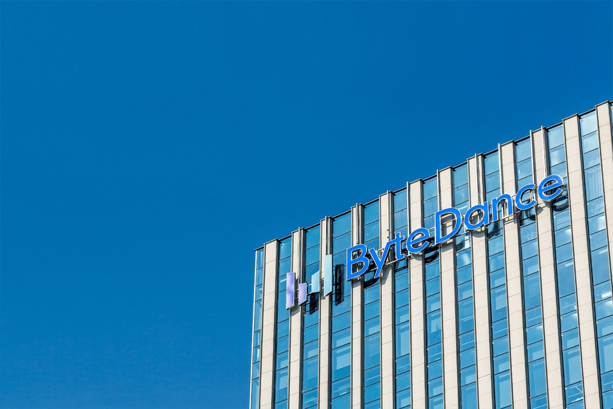 ByteDance logo on the glass facade of an office tower under a clear blue sky