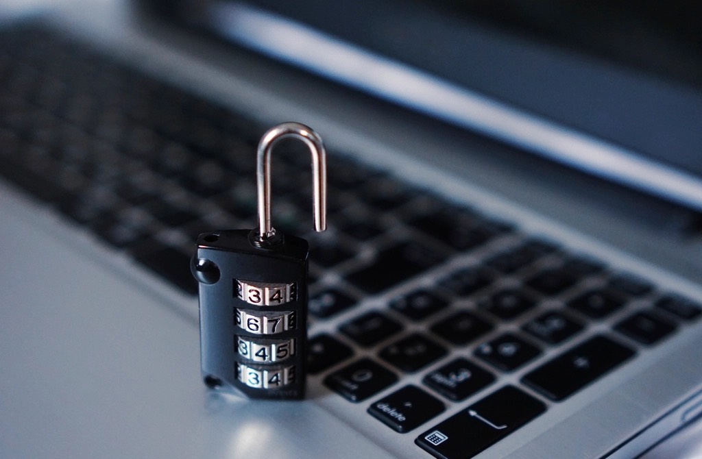 An open combination lock resting on a laptop keyboard