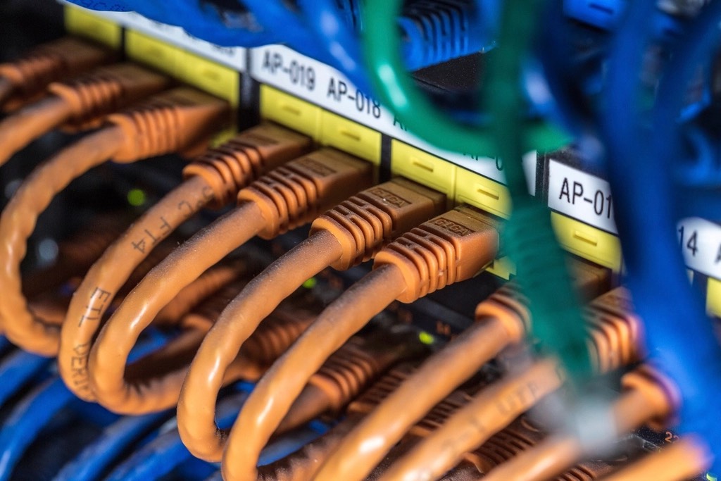 Macro photo of dense orange and blue network cable connectors on a switch