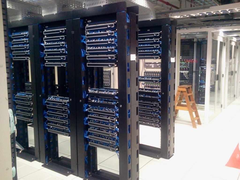 Rows of server racks and blue cabling in a data center