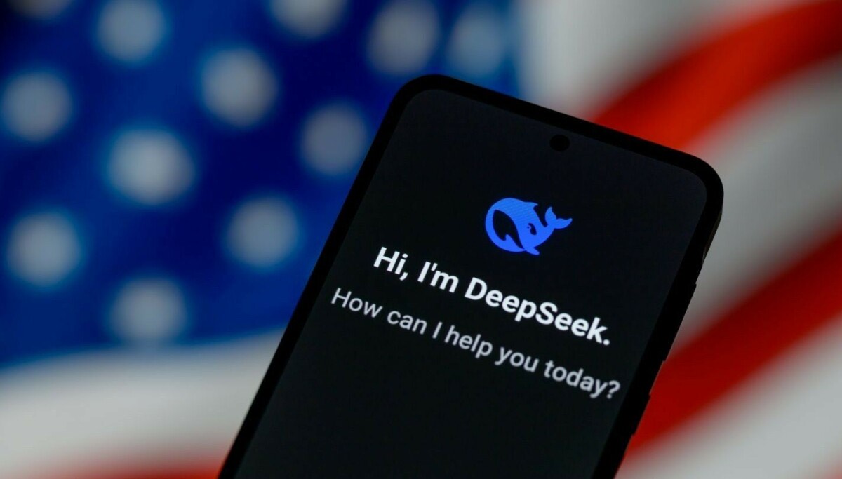A phone showing a DeepSeek greeting against a blurred US flag
