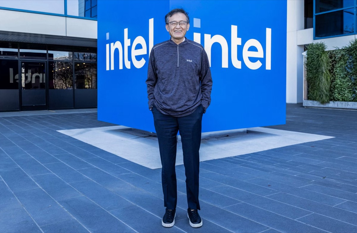 陈立武站在英特尔总部园区一块印有两个 intel 标志的蓝色背景板前