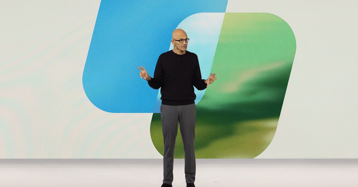 Nadella presenting in front of Copilot-colored shapes