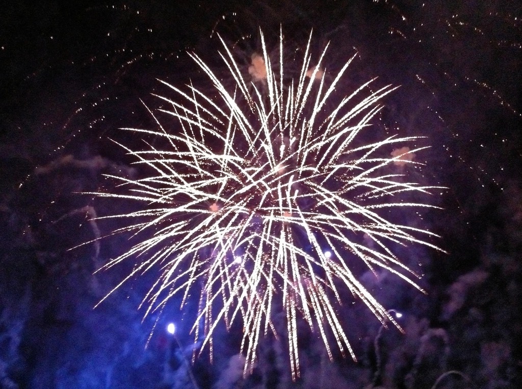 夜空中炸开的橙金色烟花，光芒照亮云层