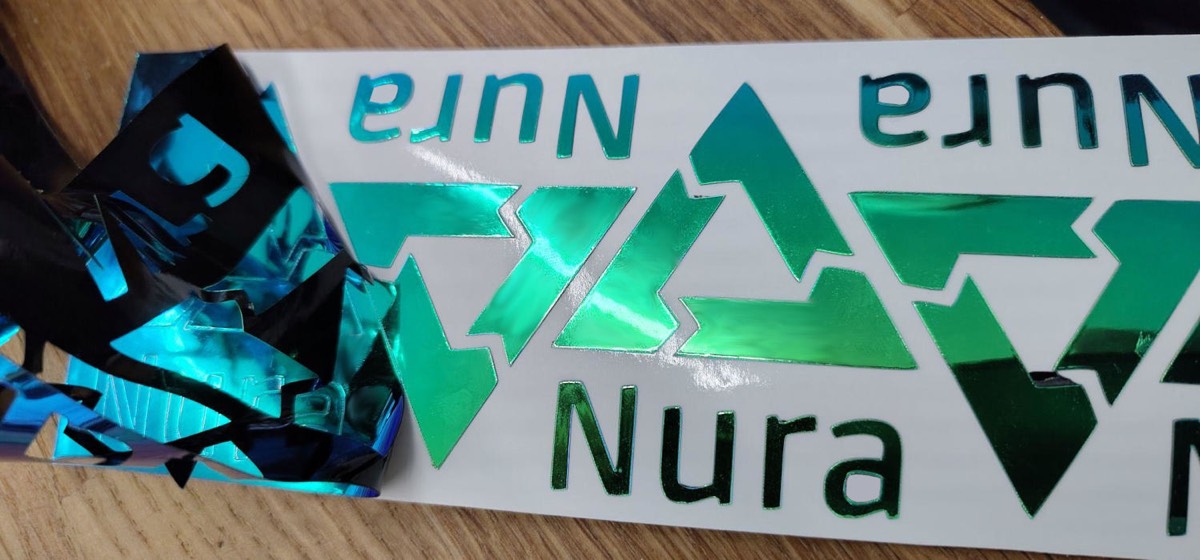 印有 Nura 三角形新标志的贴纸,部分已揭开